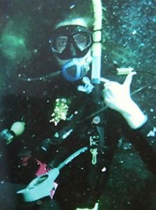 A scuba diver surrounded by dark water and bubbles.
