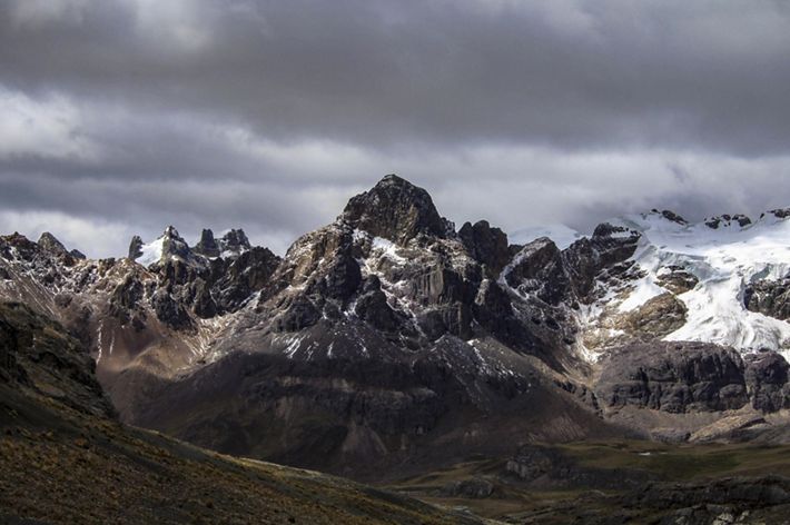 Paisaje montañoso muestra unos picos cubiertos de nieve y otros en donde ya la nieve se ha derretido.