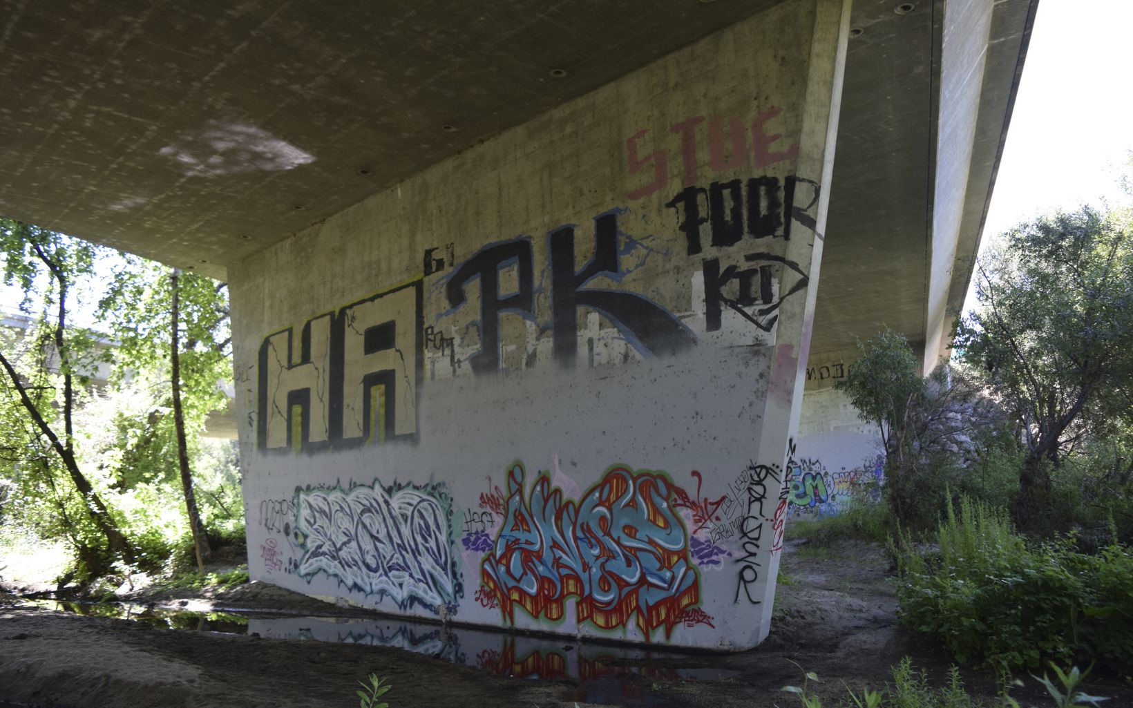 concrete support of a bridge with graffiti on it