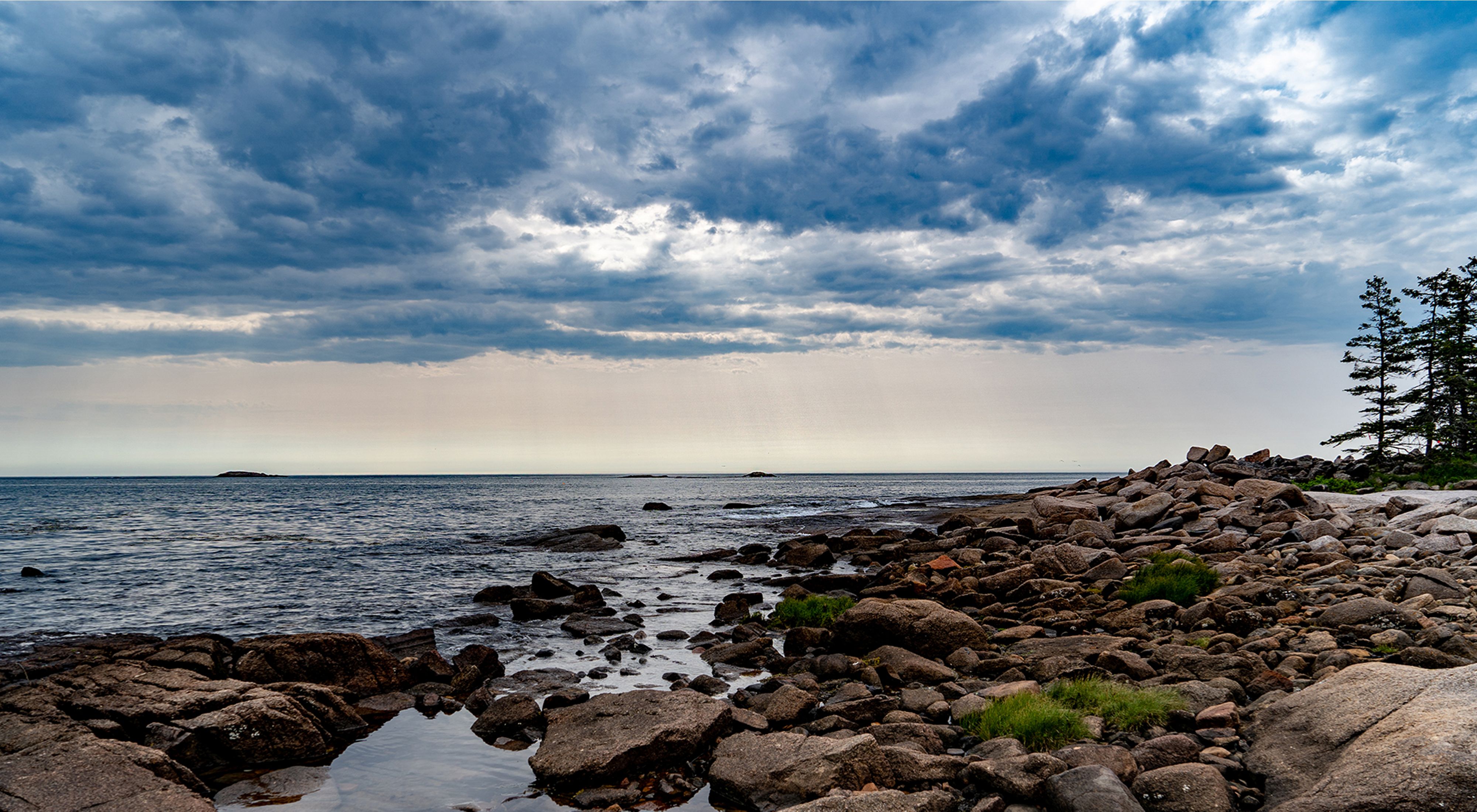 Dramatic clouds hover over a shoreline scene on Great Wass Island.
