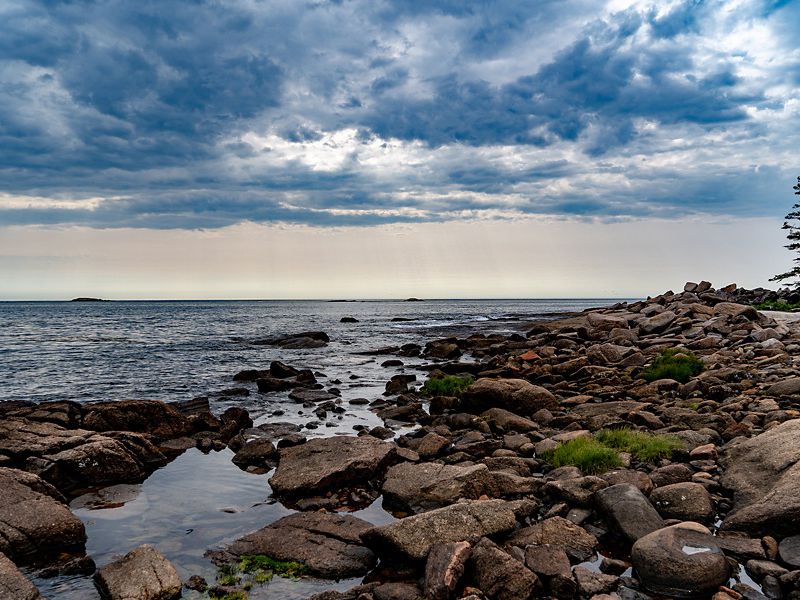 A view looking along a rocky shore out toward the ocean.