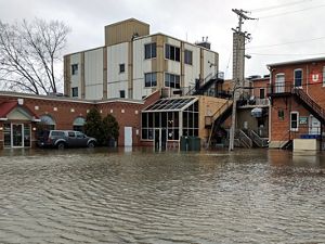Several buildings in Green Bay, Wisconsin with floodwaters coming up to the entrances.