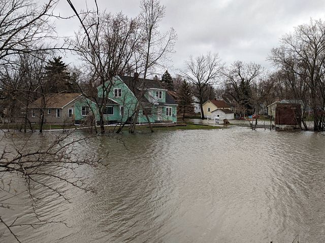 View of homes with a large area of flooding in the foreground.