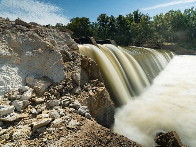 Water flowing over a large dam in a river.