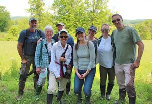 A group photo of people standing in a field and smiling. 