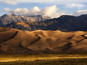 Sunrise at Great Sand Dunes National Park and Preserve with the Crestone Peaks of the Sangre de Cristo Mountains in the background.