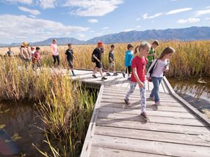 Kids running on a boardwalk at the Great Salt Lake Shorelands preserve.