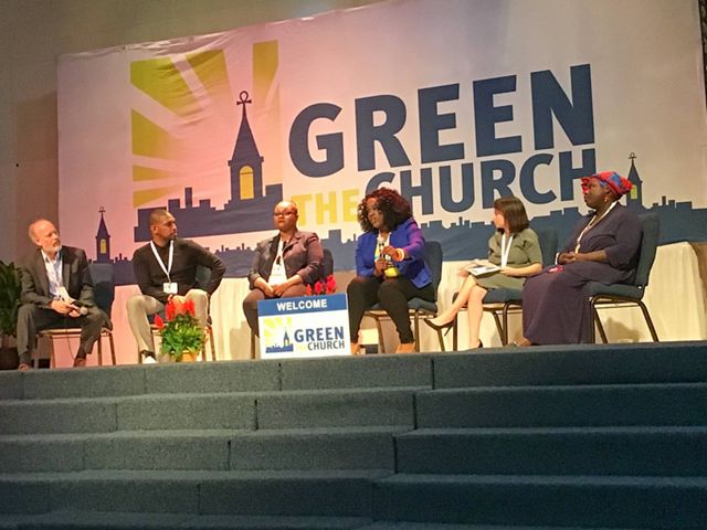 A panel of six people sitting in chairs on a stage in front of a banner reading 'Green The Church.'