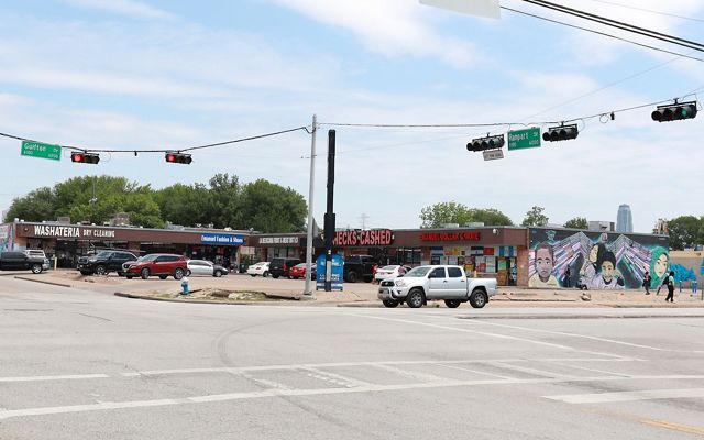 An intersection with paved roads and concrete parking lots.