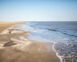 Gentle waves lapping on a sandy beach.