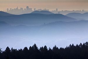 Rolling hills in the foreground with the silhouette of the skyline of San Francisco in the background.