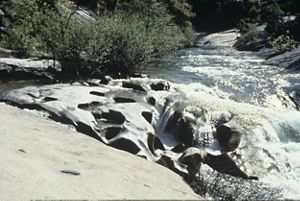 Water cascading over boulders in a river.