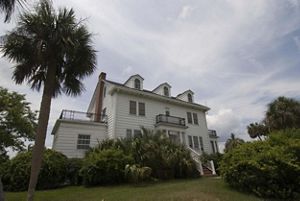 House on a property with palm trees.