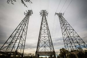 Looking up at electrical transmission towers.