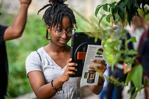 A young woman holding and reading an iPad.
