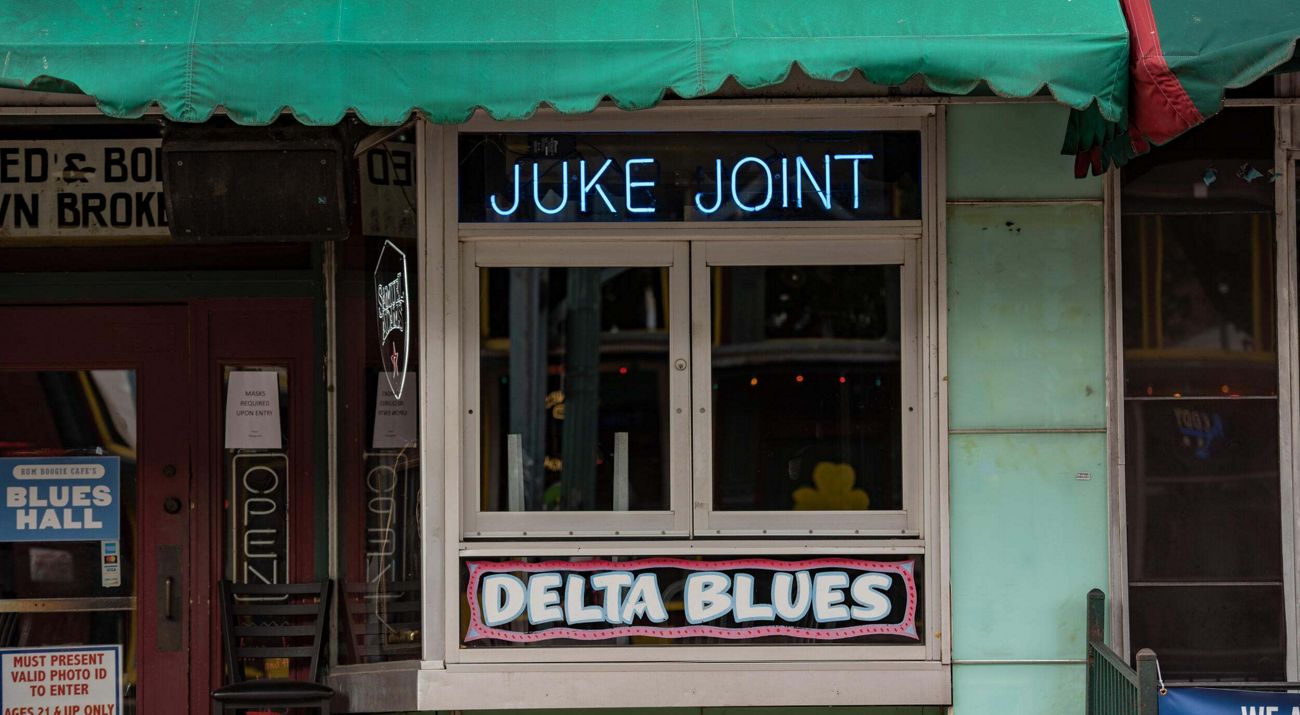 Window at a bar with an illuminated sign that reads, Juke Joint.
