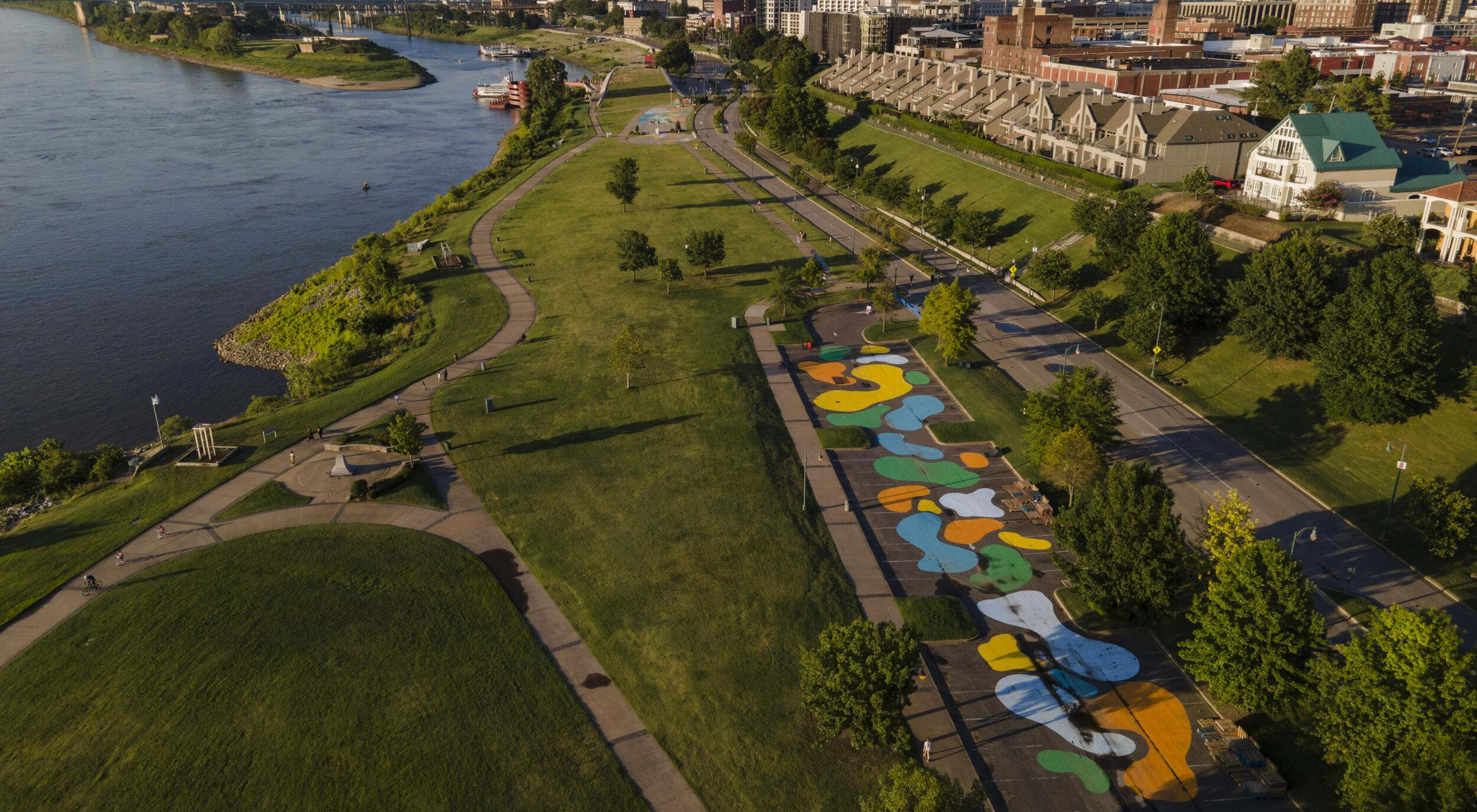 Aerial view of a city park alongside a river.