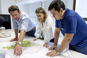 Staff standing over a desk looking down at a map.