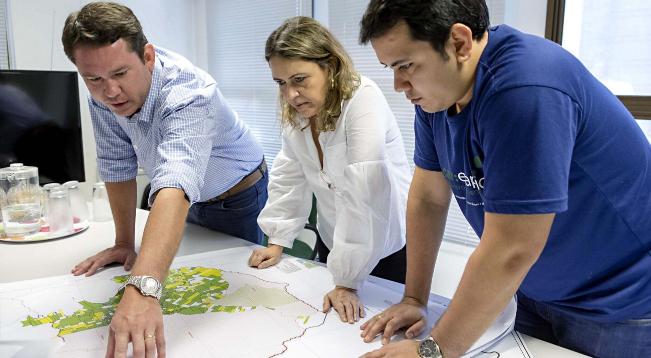 Staff standing over a desk looking down at a map.