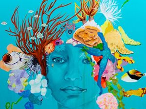 A bright turquoise mural of a woman's face with sea creatures as hair.
