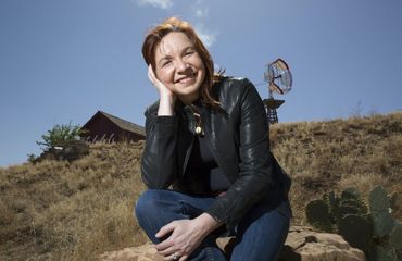 a photo of a woman crouched down looking at the camera.