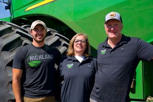 Two farmers standing in front of a tractor.