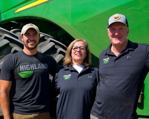 Two farmers standing in front of a tractor.