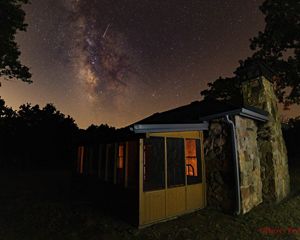 The cabin of John Joseph Mathews frames the Pawhuska night sky.