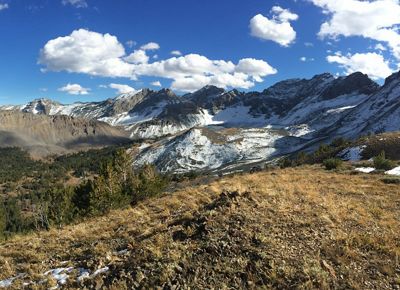 Wide view of a mountain range under a blue sky.