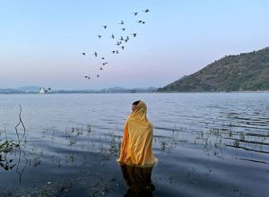 A man standing in freezing cold water waiting for Sun God to arrive during Chatth Puja Festival.