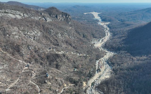 Aerial view of a river valley with a large lake in the background.