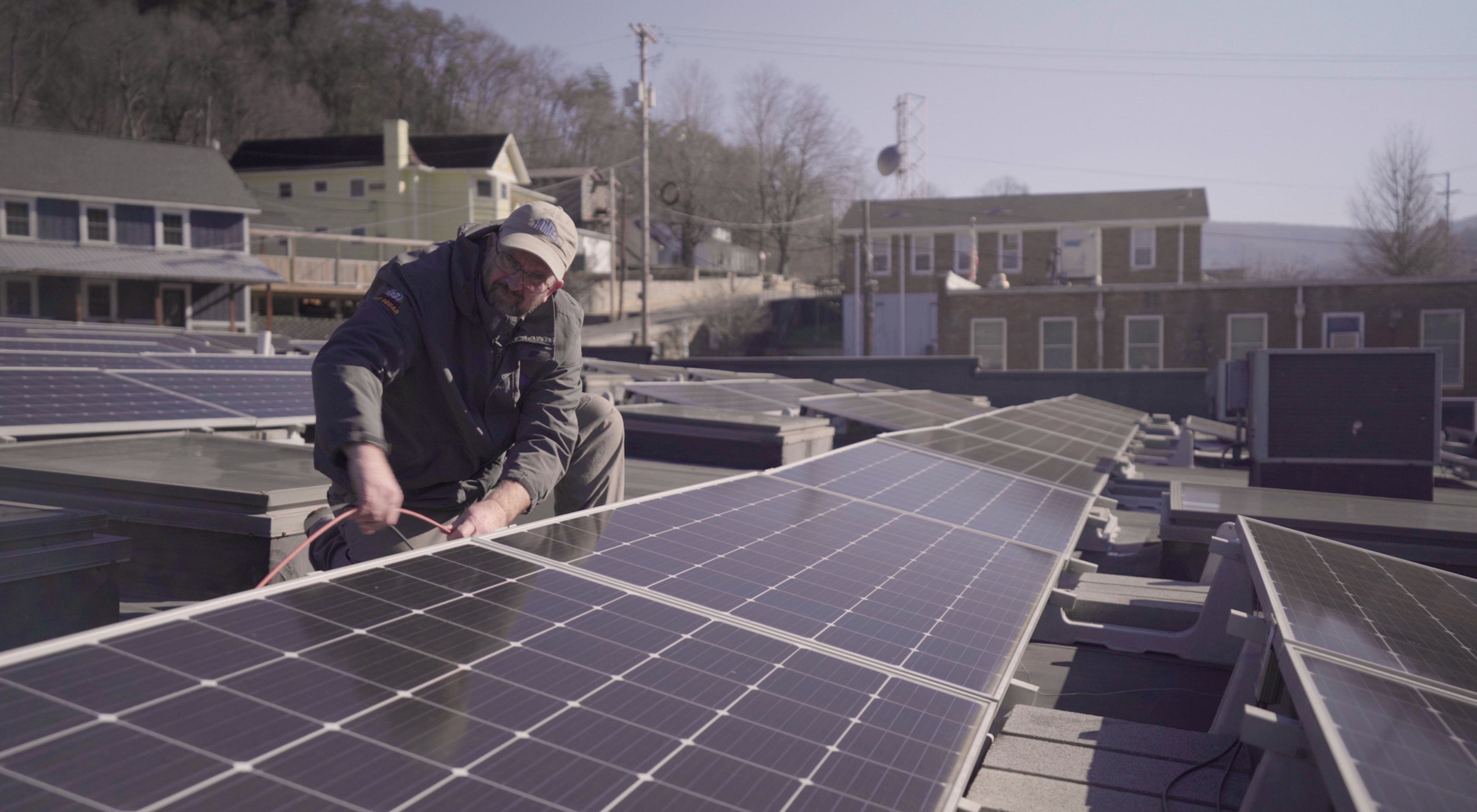 A man works on solar panels on a roof in Kentucky.
