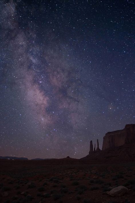 Image of the night sky, appearing purple, with the Milky Way visible.