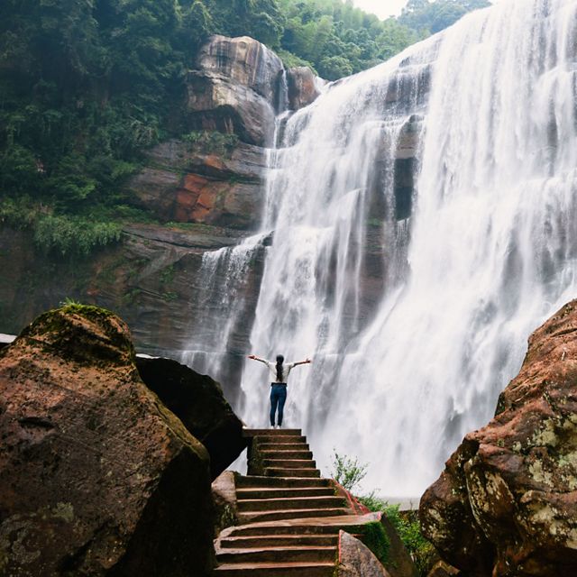Person standing in front of waterfall