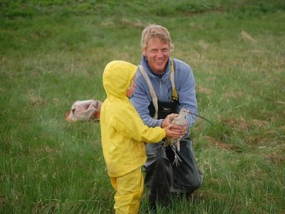 A man with his son releasing a bird into nature.