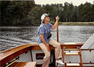 A woman sits on the edge of a boat that floats in Nassawango Creek.