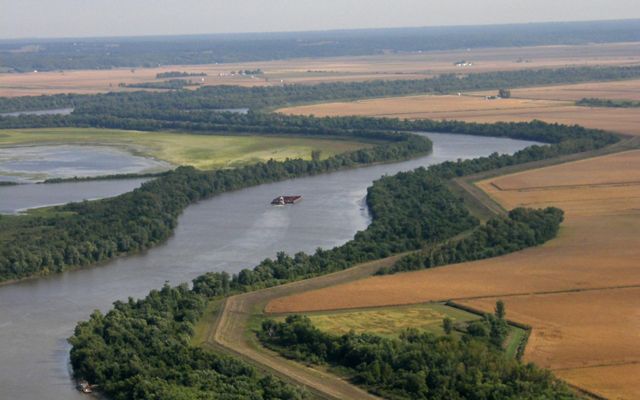 A broad river with fields on either side.