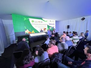 Presentacion panel de dos personas presentando a un publico con una pantalla digital en el fondo.
