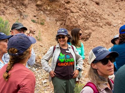 A group of people gathered and talking in a dirt ditch.