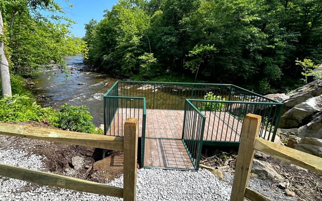 An overlook platform facing a river with blue skies above.