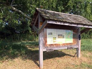 Preserve visitor kiosk. The large wooden message board is protected by an overhanging shingled roof.