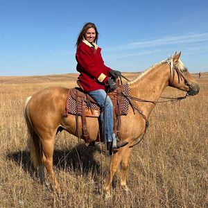 Nancy Labbe on a fawn colored horse.