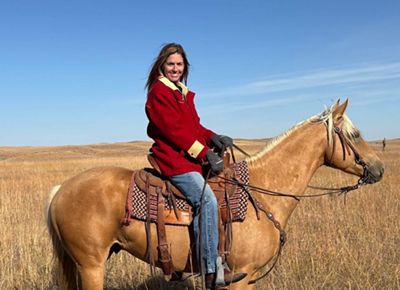 Nancy Labbe on a fawn colored horse.
