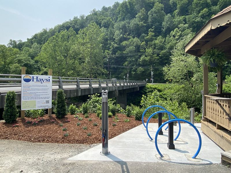 Three blue bike racks next to a wooden gazebo and a riverwalk in Haysi, VA.