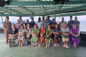 A large group of people sit and pose for a group photo.