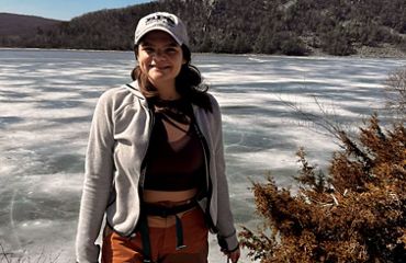 Emma Schatz standing in front of a frozen lake.