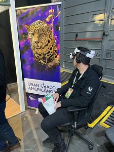 Persona sentada con un aparato de realidad virtual en su cabeza. 