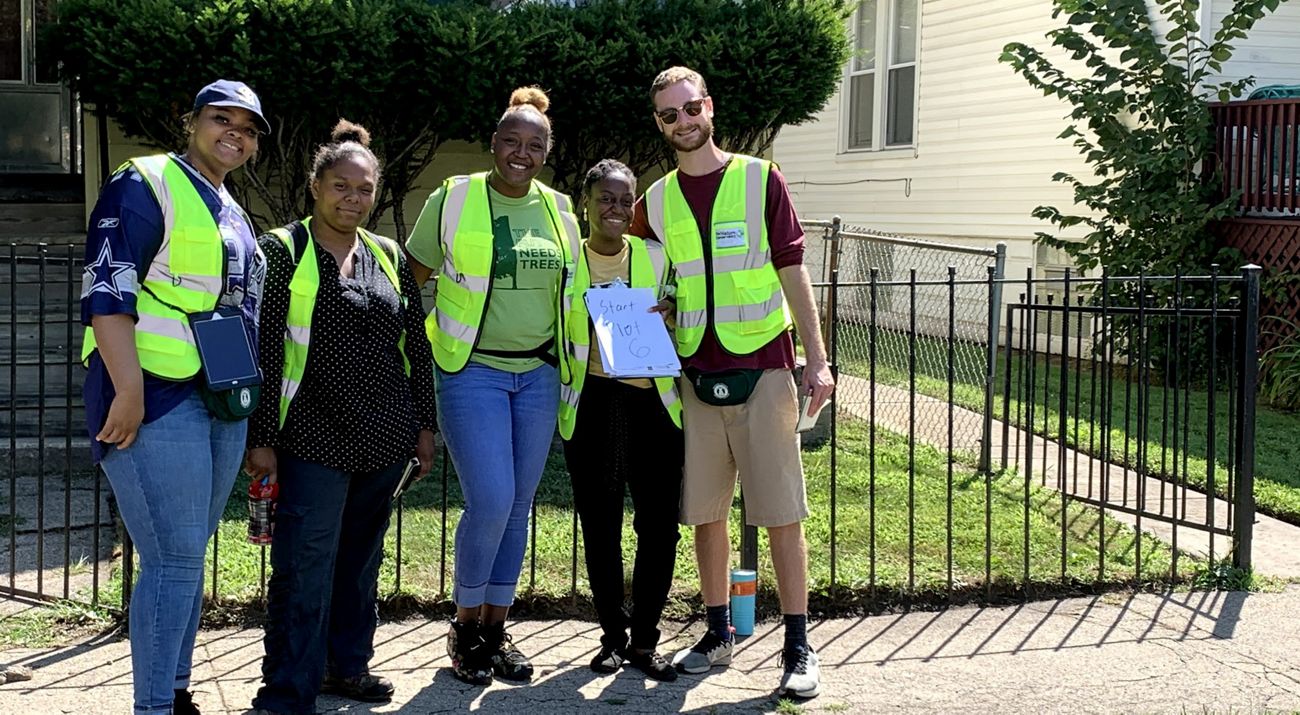 Five tree health researchers stand in front of a house in an urban neighborhood.