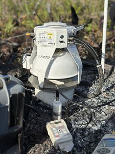 A big, white, metal piece of equipment is situated among rocks.