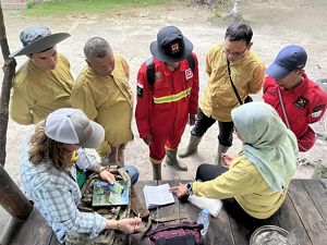 A group of people look at a map before a controlled burn.